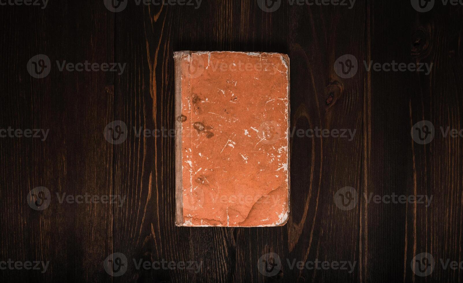Closed book on vintage wooden background. Old book on the wooden table. Closed book with empty cover laying on wooden table. photo