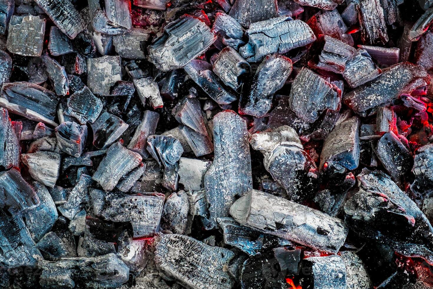 The texture of burning firewood and charcoal with the remnants of the heat. Ash after the fire. Light back. photo