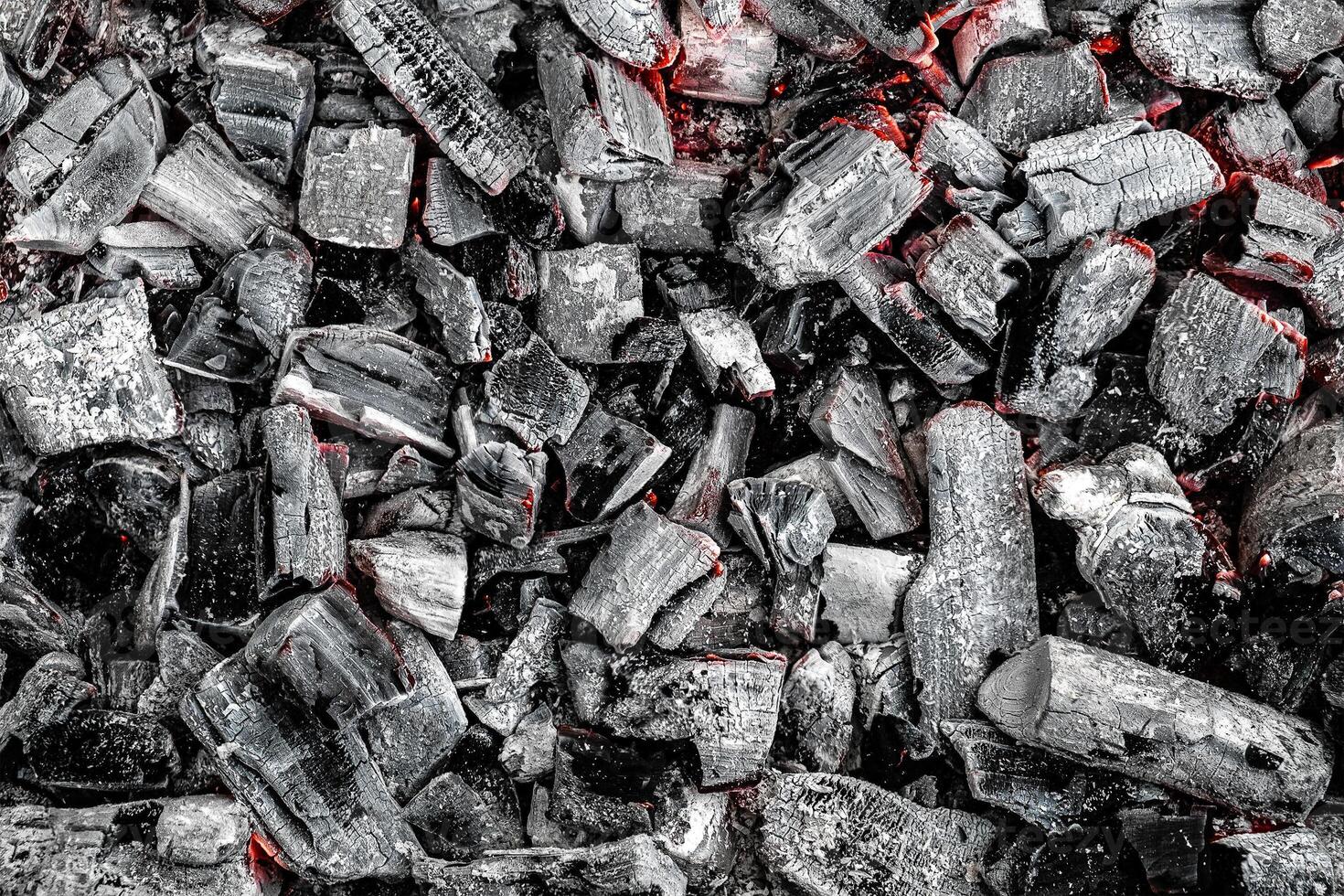 The texture of burning firewood and charcoal with the remnants of the heat. Ash after the fire. Light back. photo