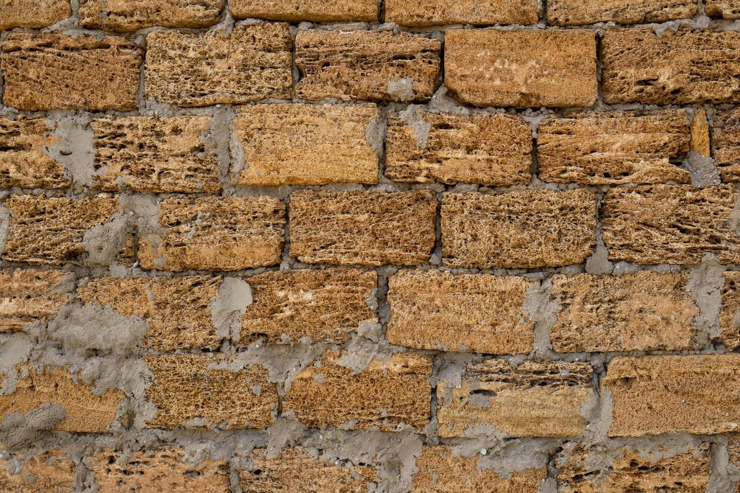 Brick wall of yellow shell rock. Closeup of shellstone texture. Background wall with shell rock. Old wall. Texture limestone photo