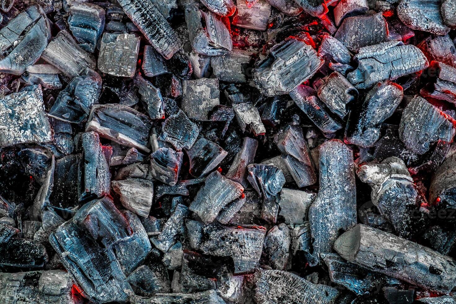 The texture of burning firewood and charcoal with the remnants of the heat. Ash after the fire. Light back. photo