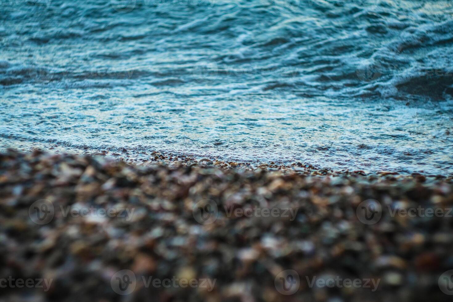 Wave running onto the coast. Foreground is blurred and focus is on the sea water. Natural background. photo