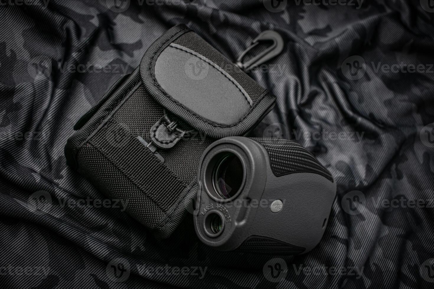 A small modern optical rangefinder. An electronic device for measuring distance. Dark camouflage back. photo