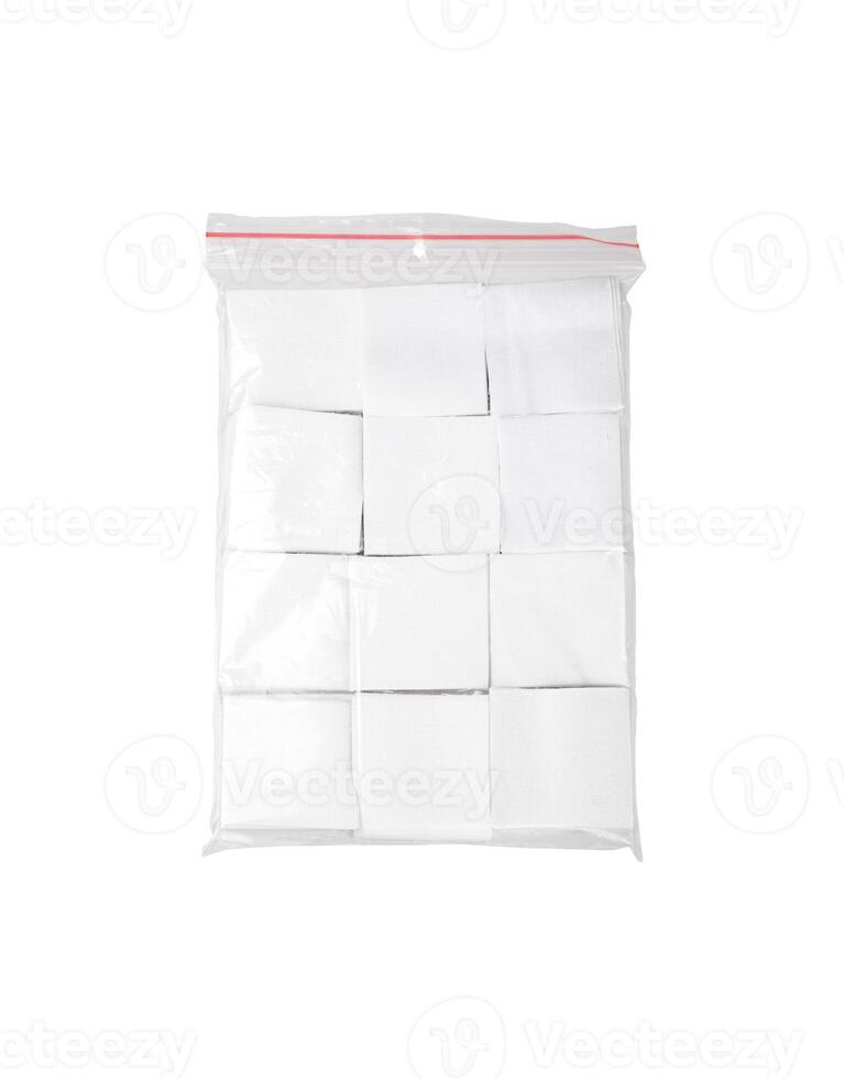 Patches for cleaning weapons isolate on a white back. White square scraps of fabric stacked in a pile and packed in a plastic bag. photo