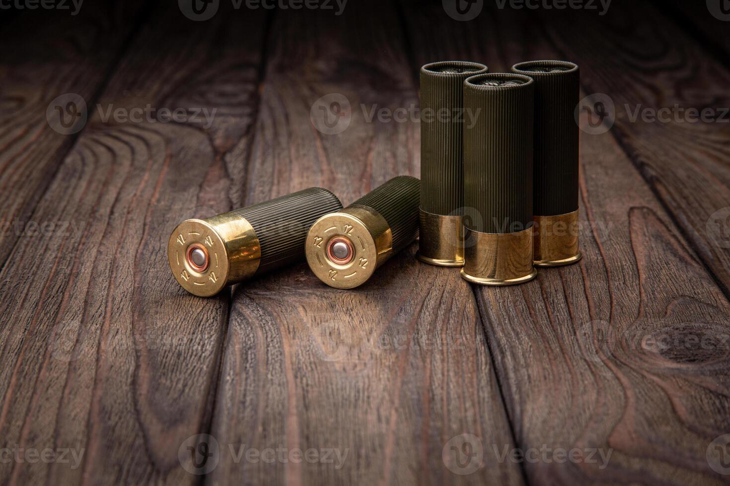 Shotgun cartridges on a brown wooden table. Ammunition for 12 gauge smoothbore weapons. photo