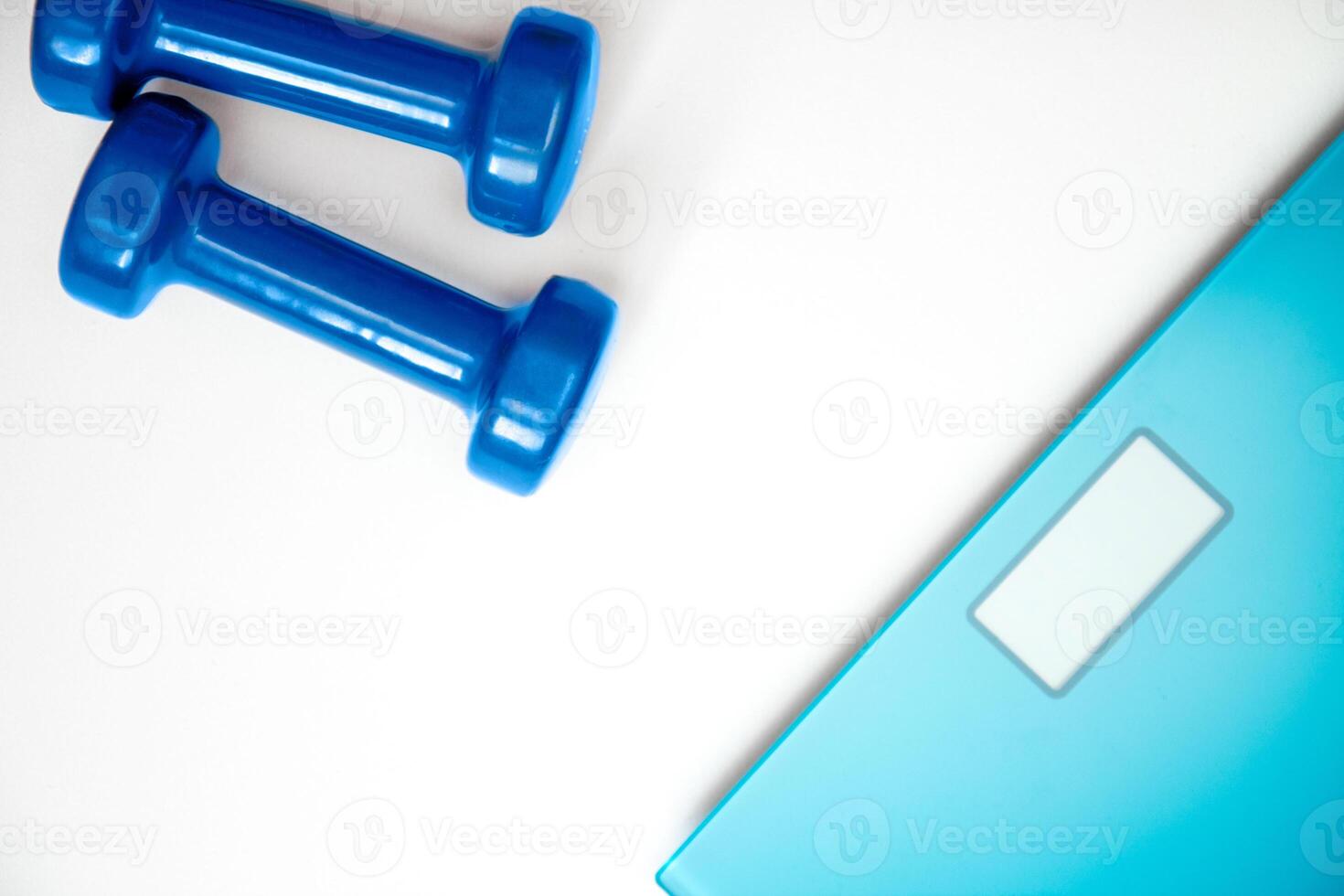 scales and dumbbells on a white photo