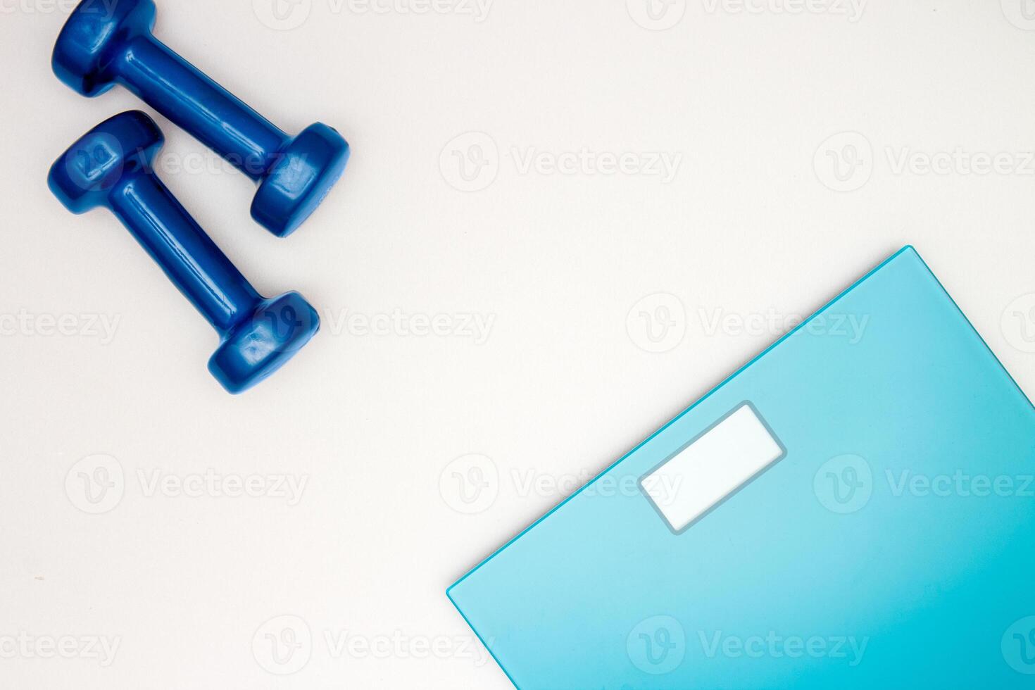 scales and dumbbells on a white photo