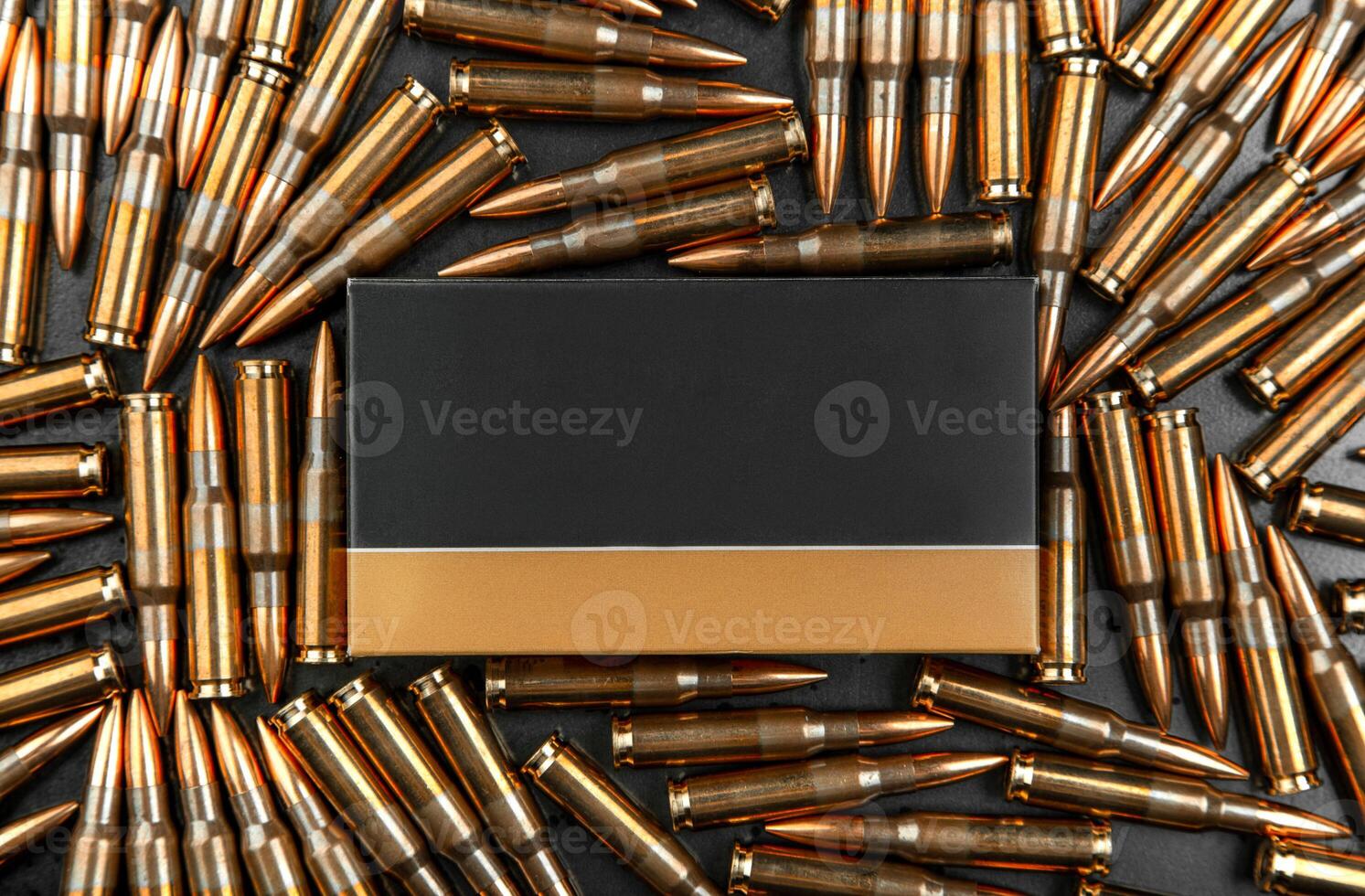 Background from rifle cartridges on a gray metal back. A box of cartridges. Copy space for text in the center of the image in the form of a rectangle. photo