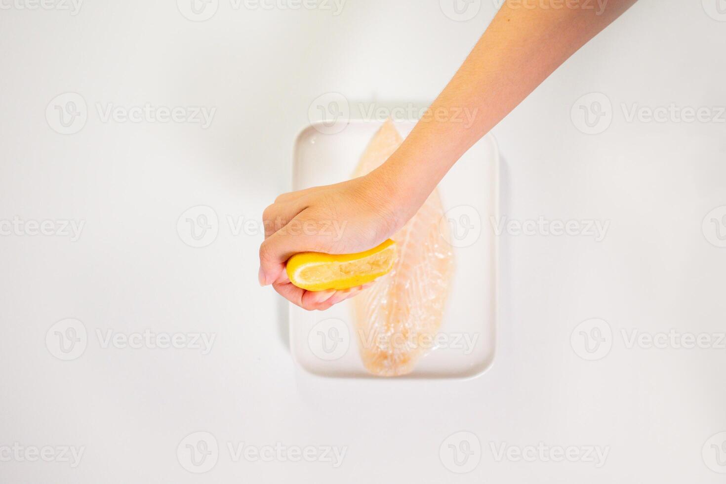 Squeezing Lemon on a Raw dory photo