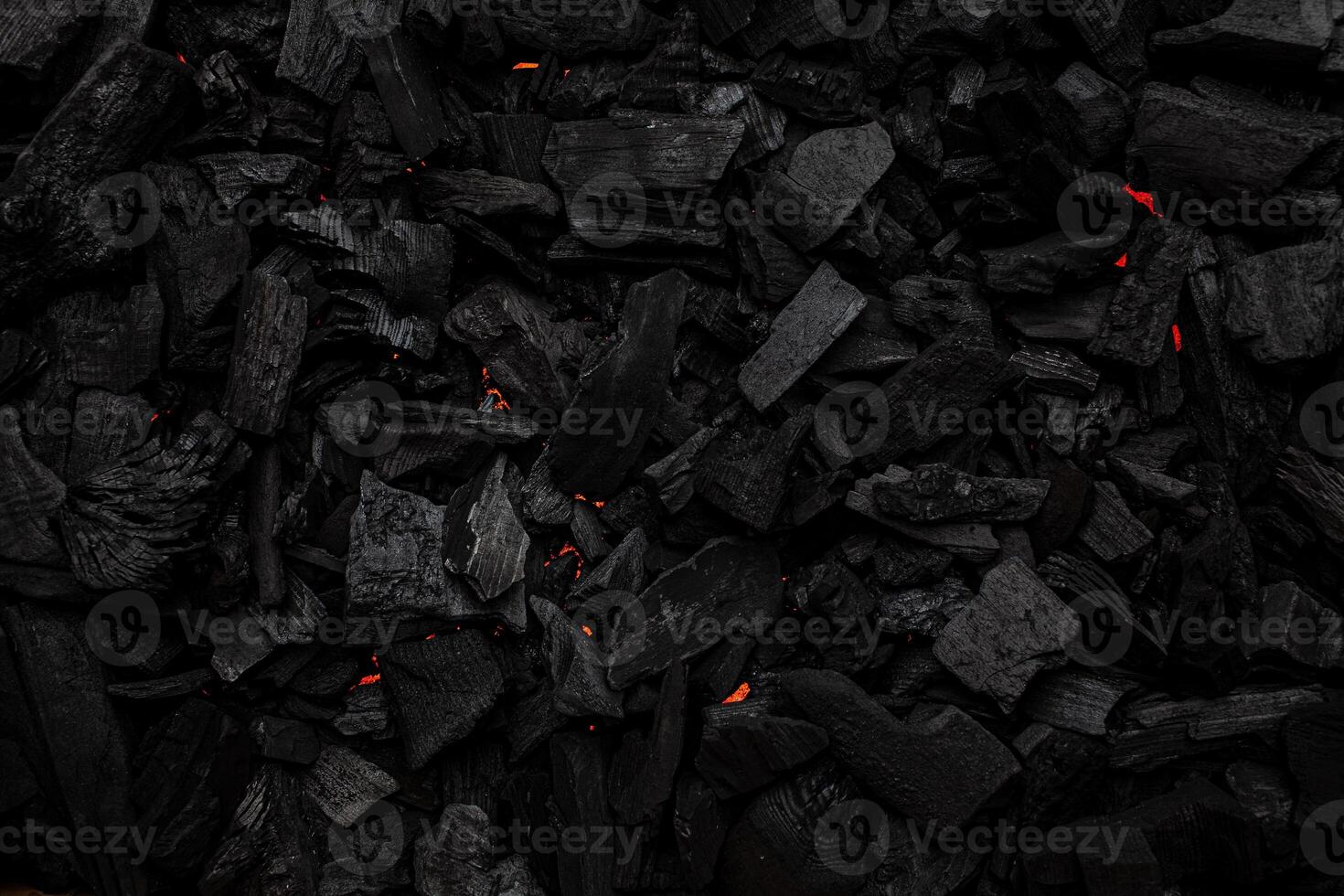 Charcoal with red streaks of heat. Textured dark back. photo