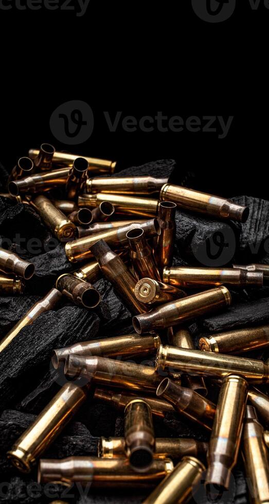 Empty shells from weapons on black smoldering coals. Consequences of the war. Dark back. photo