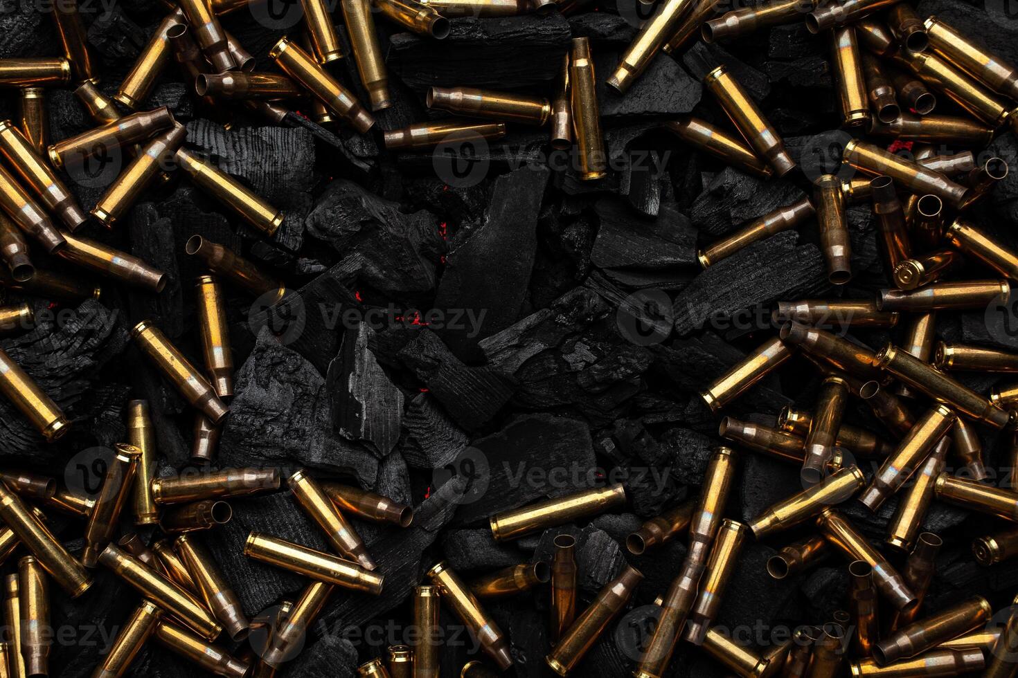 Empty shells from weapons on black smoldering coals. Consequences of the war. Dark back. photo