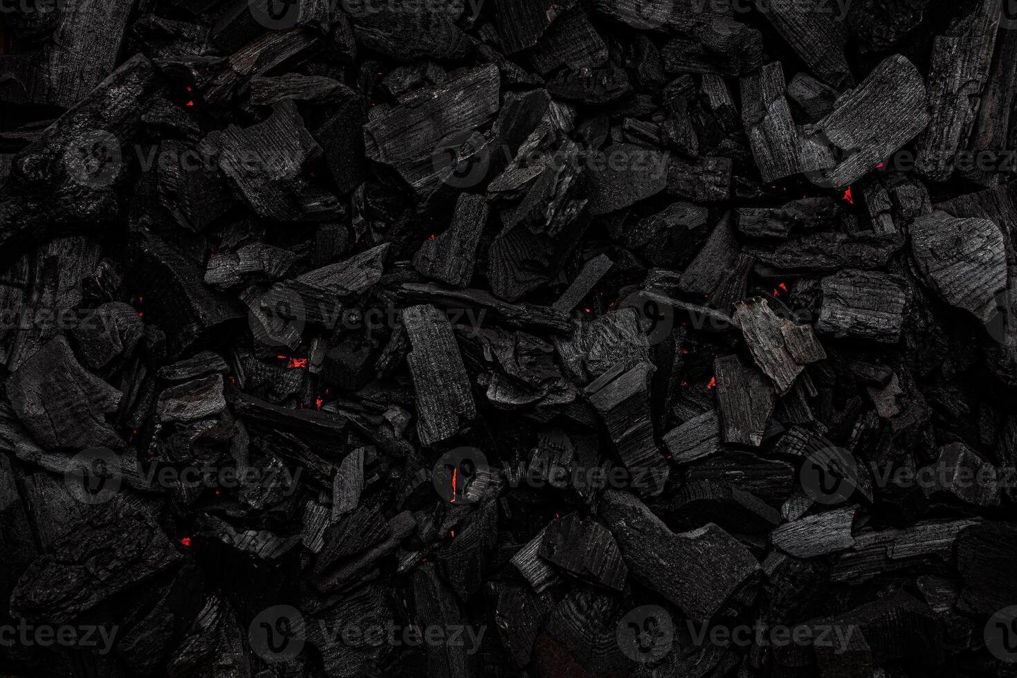 Charcoal with red streaks of heat. Textured dark back. photo