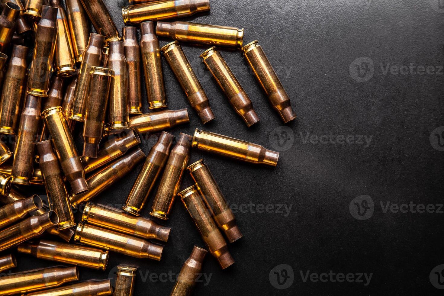Background from empty cartridges for rifles and carbines. Shiny brass shells scattered on the surface. photo