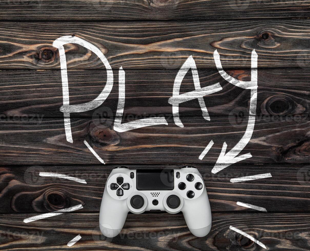 white gamepad on a dark wooden background. word play and an arrow pointing to the gamepad. photo