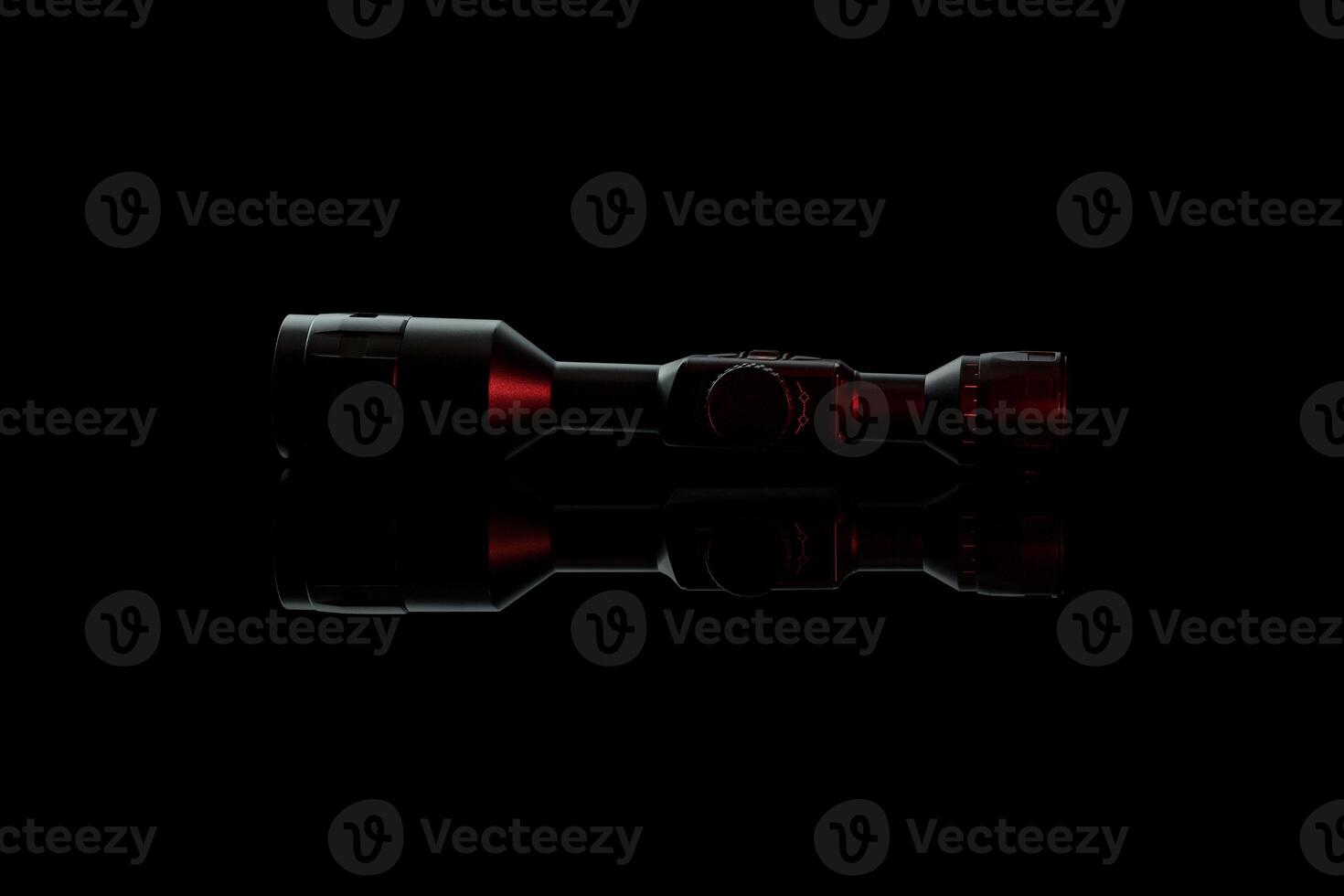 Modern telescopic sight on a smooth mirrored surface. The sight is highlighted in red. A device for shooting at long distances. photo