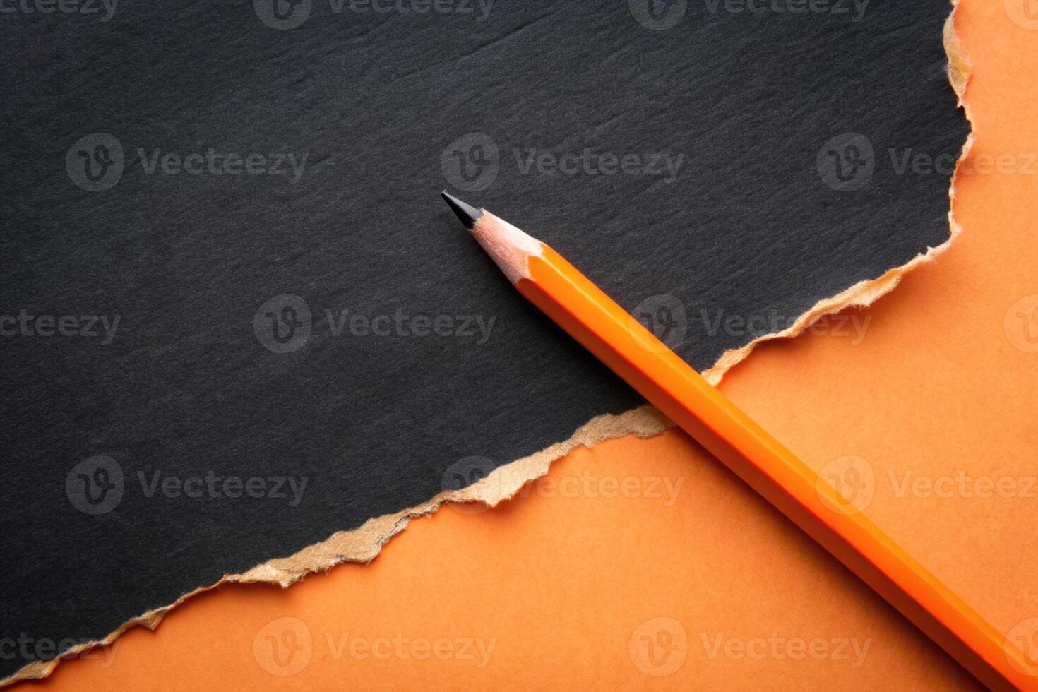 Orange paper torn ripped with pencil on black background for your presentation background photo