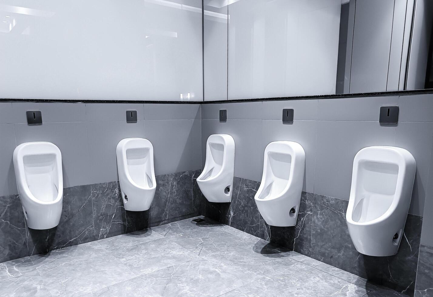 Men's room with white porcelain urinals photo