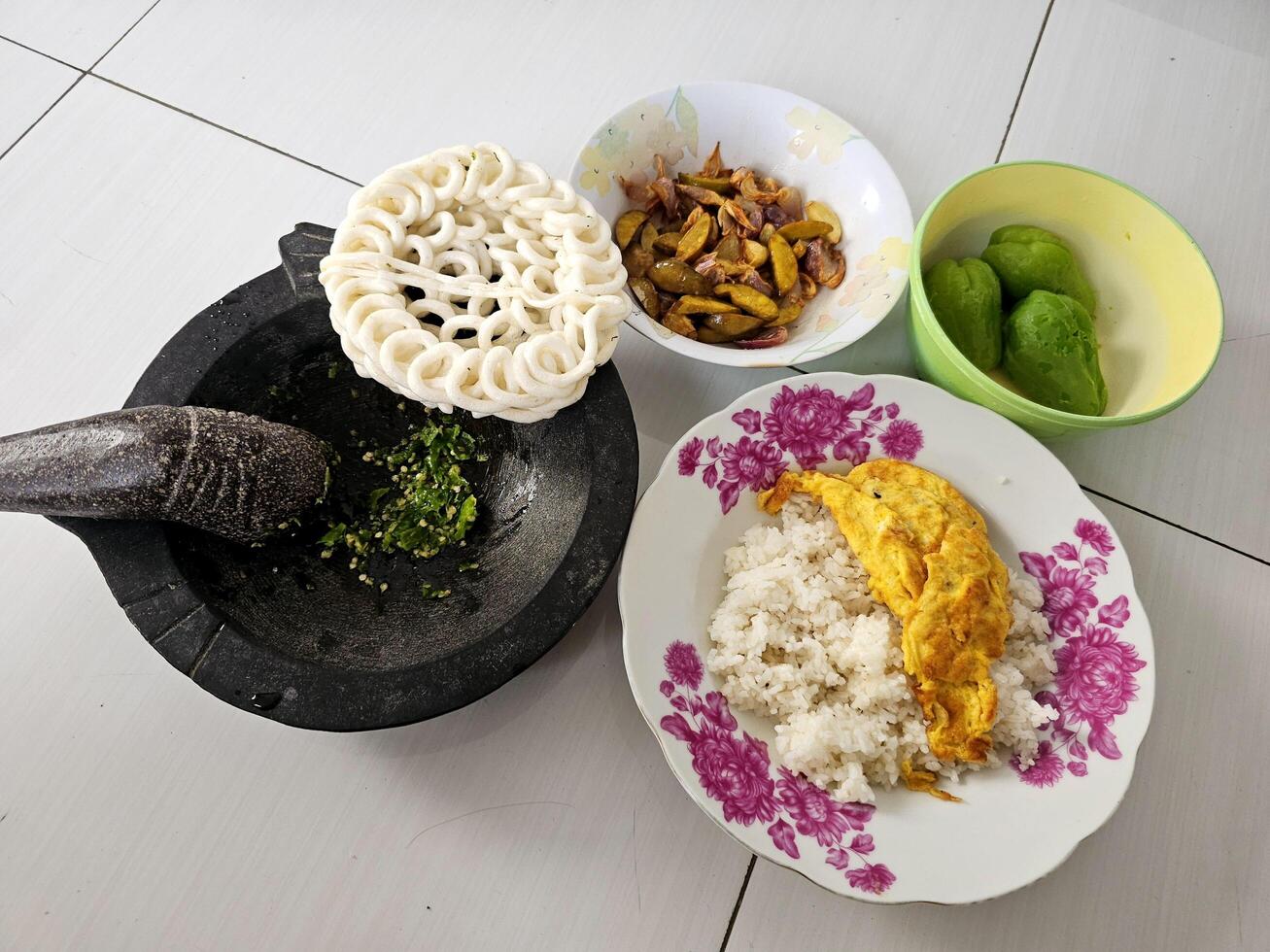 A simple lunch plate consisting of rice, omelet and some vegetables plus green chili sauce photo