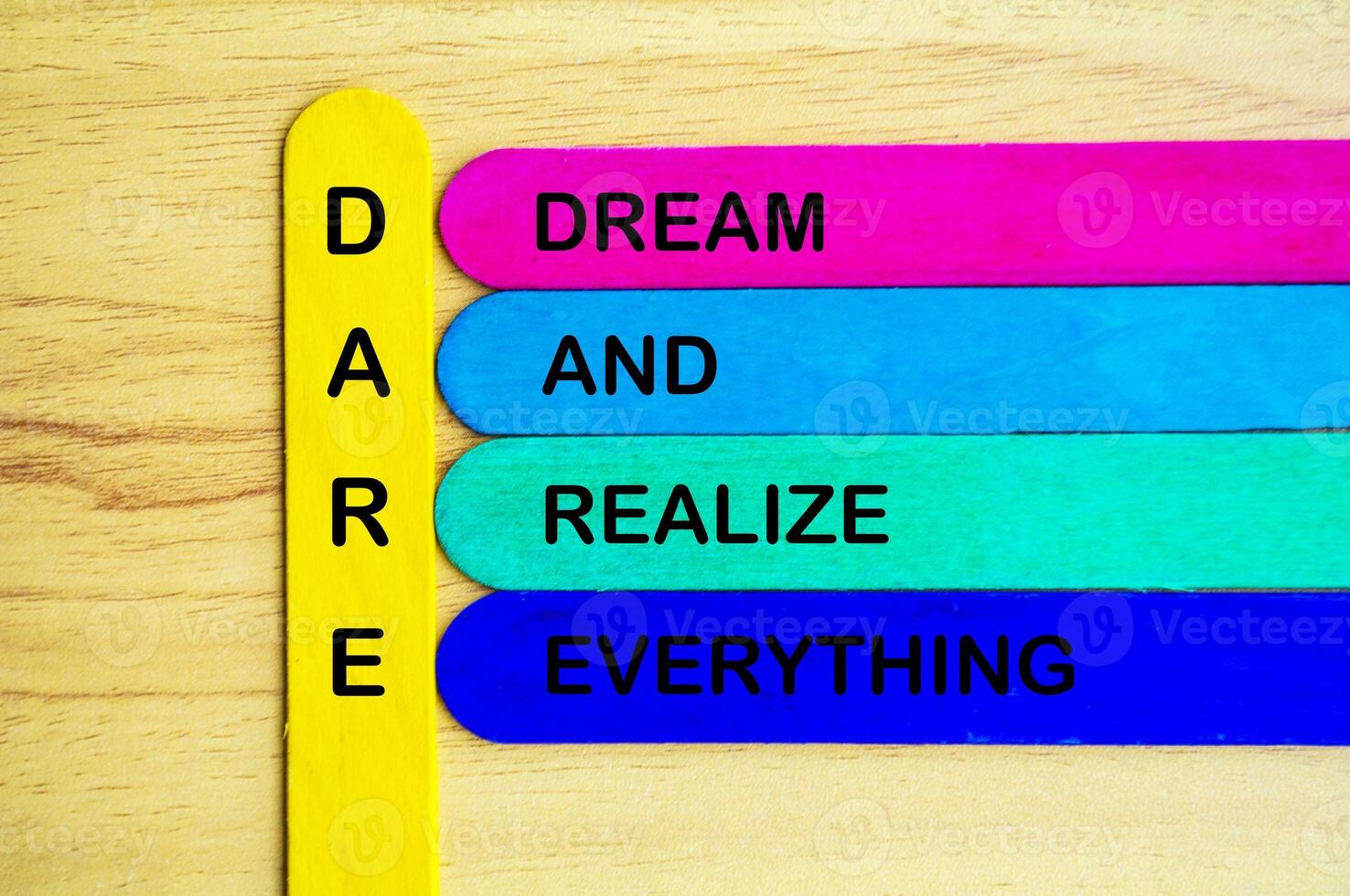 Dare represent Dream And Realize Everything text on multicolored sticks. Daring concept photo
