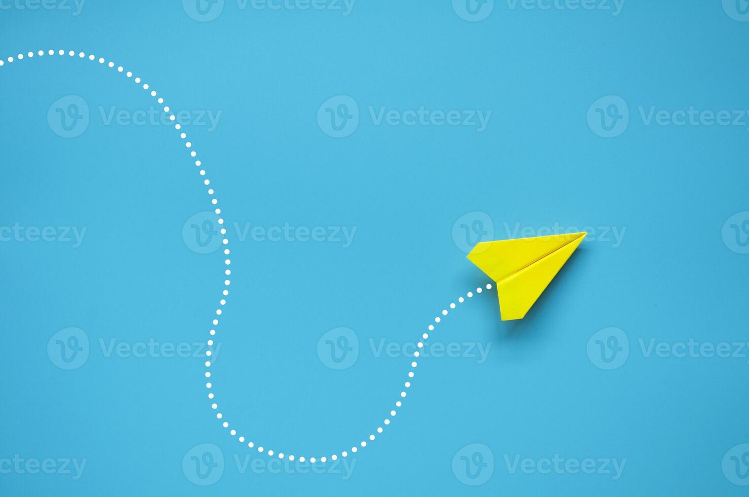 Top view of yellow paper airplane finding the right direction to fly. Exploring solution concept photo