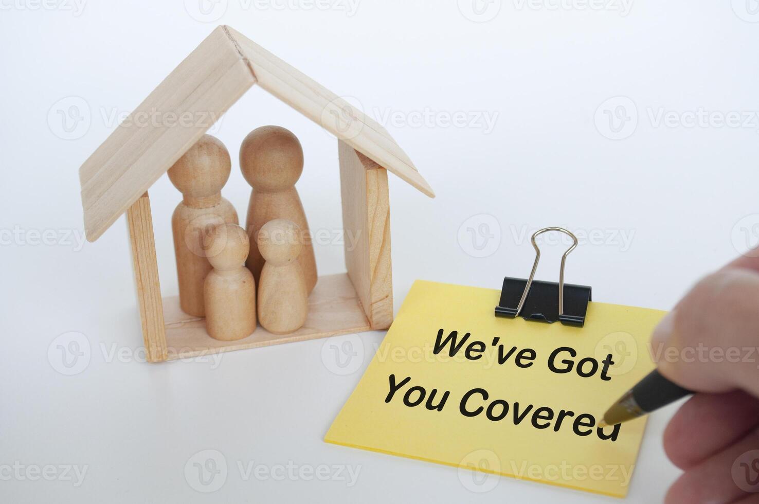 We have got you covered text written on yellow notepad with wooden family dolls figure background photo