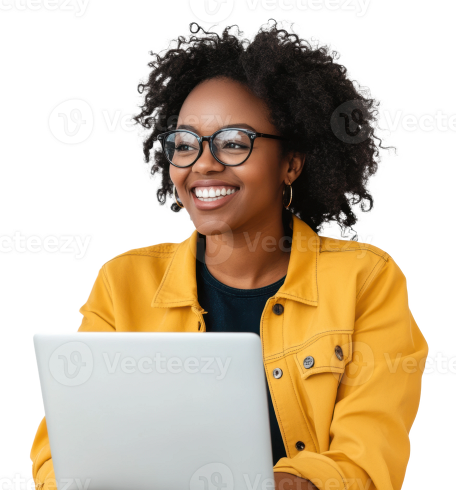 A smiling woman with curly hair works on a laptop while wearing a yellow jacket in a bright setting, cut out - stock . png