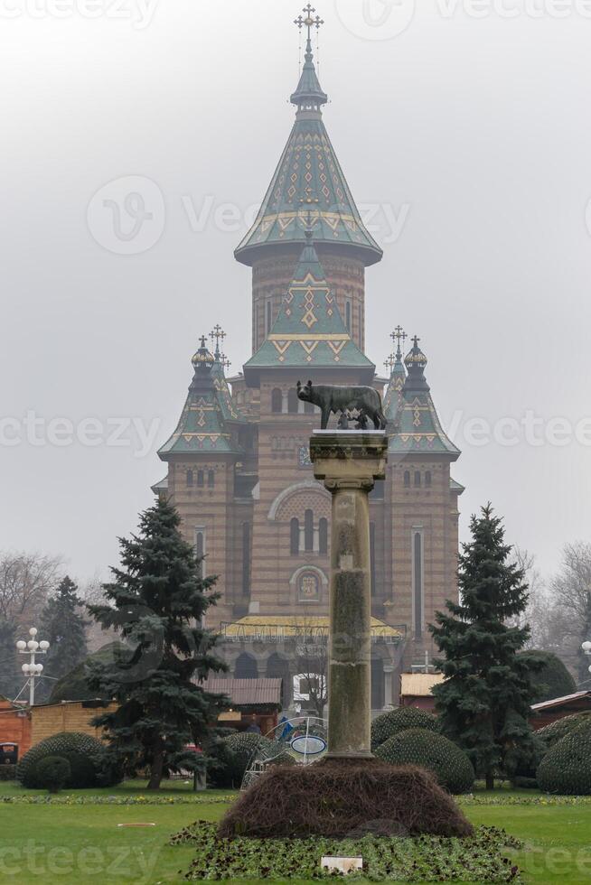 The Capitoline Wolf, she-wolf with Romulus and Remus, with the metropolitan orthodox cathedral in the background photo