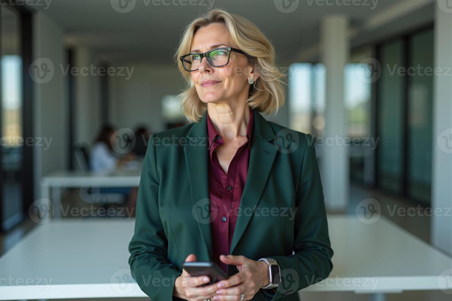 photo of woman in green suit outfit and holding mobile phone in the office,