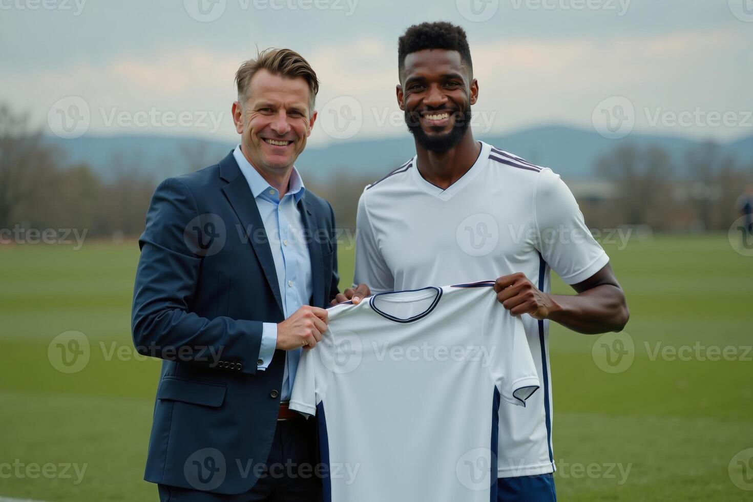 photo of coach and player holding shirt in the stadium field at signing contract event,