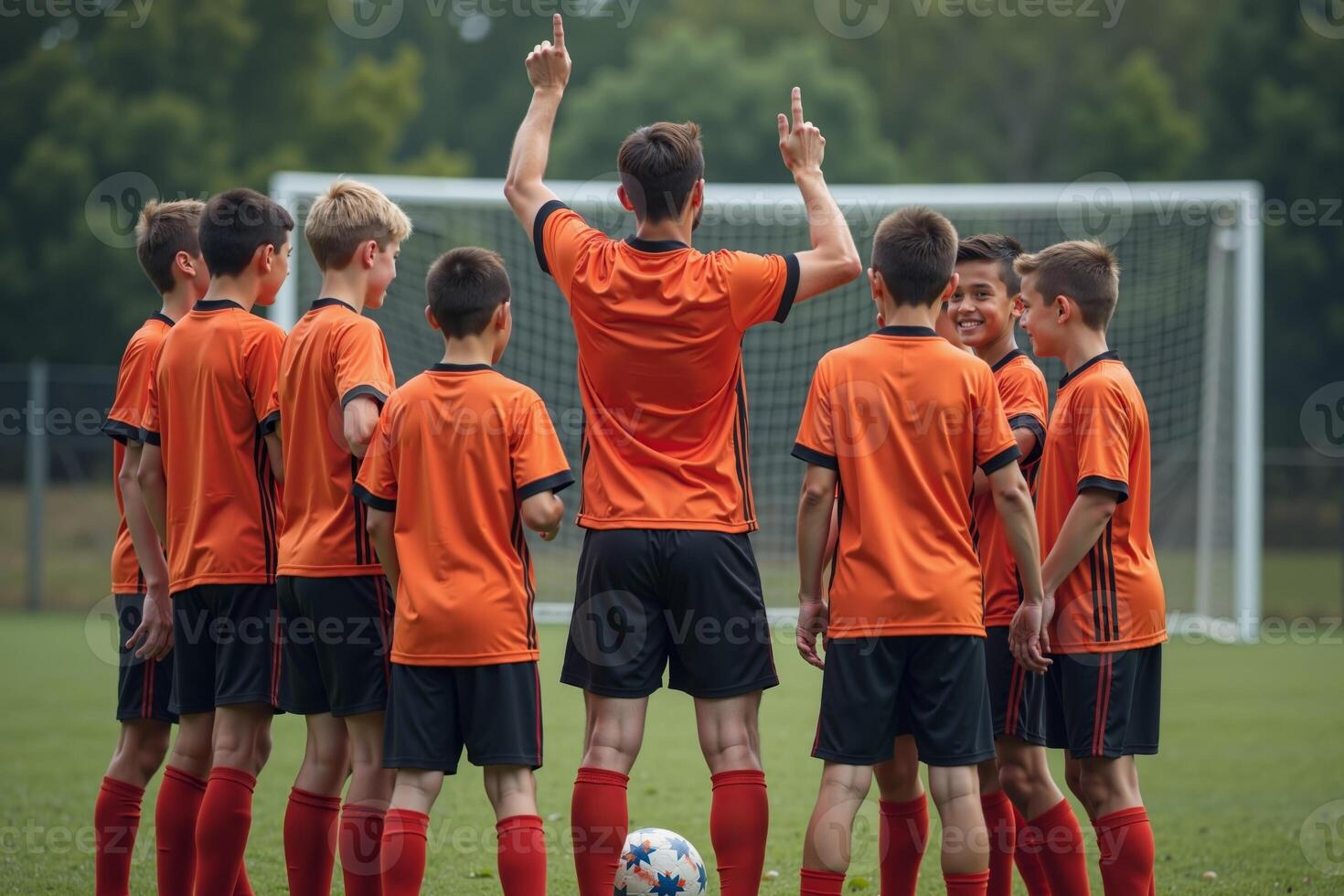 photo of coach instructor trainer teaching teenage player at soccer field,