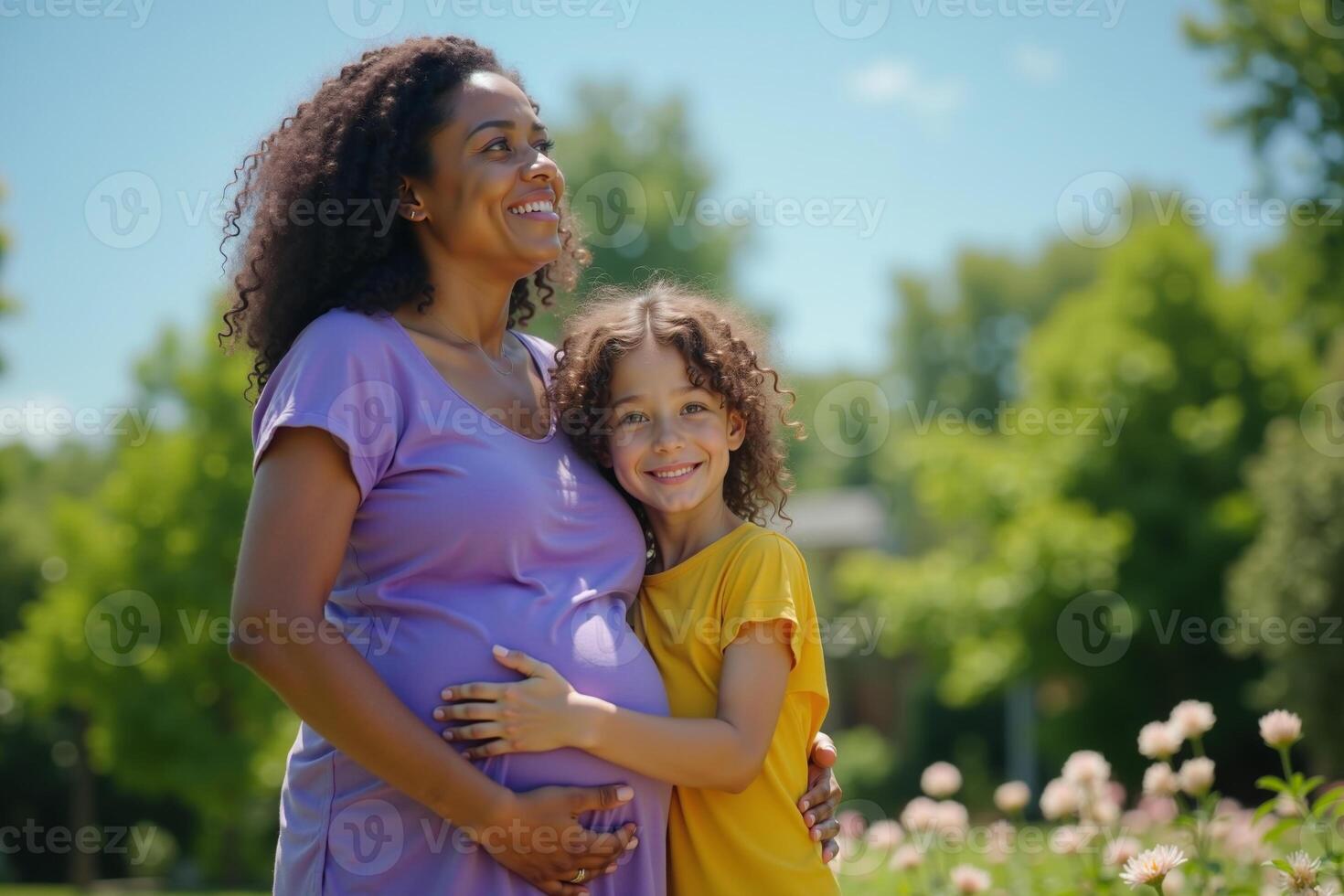 photo of pregnant woman and her kid standing and hugging at garden field,
