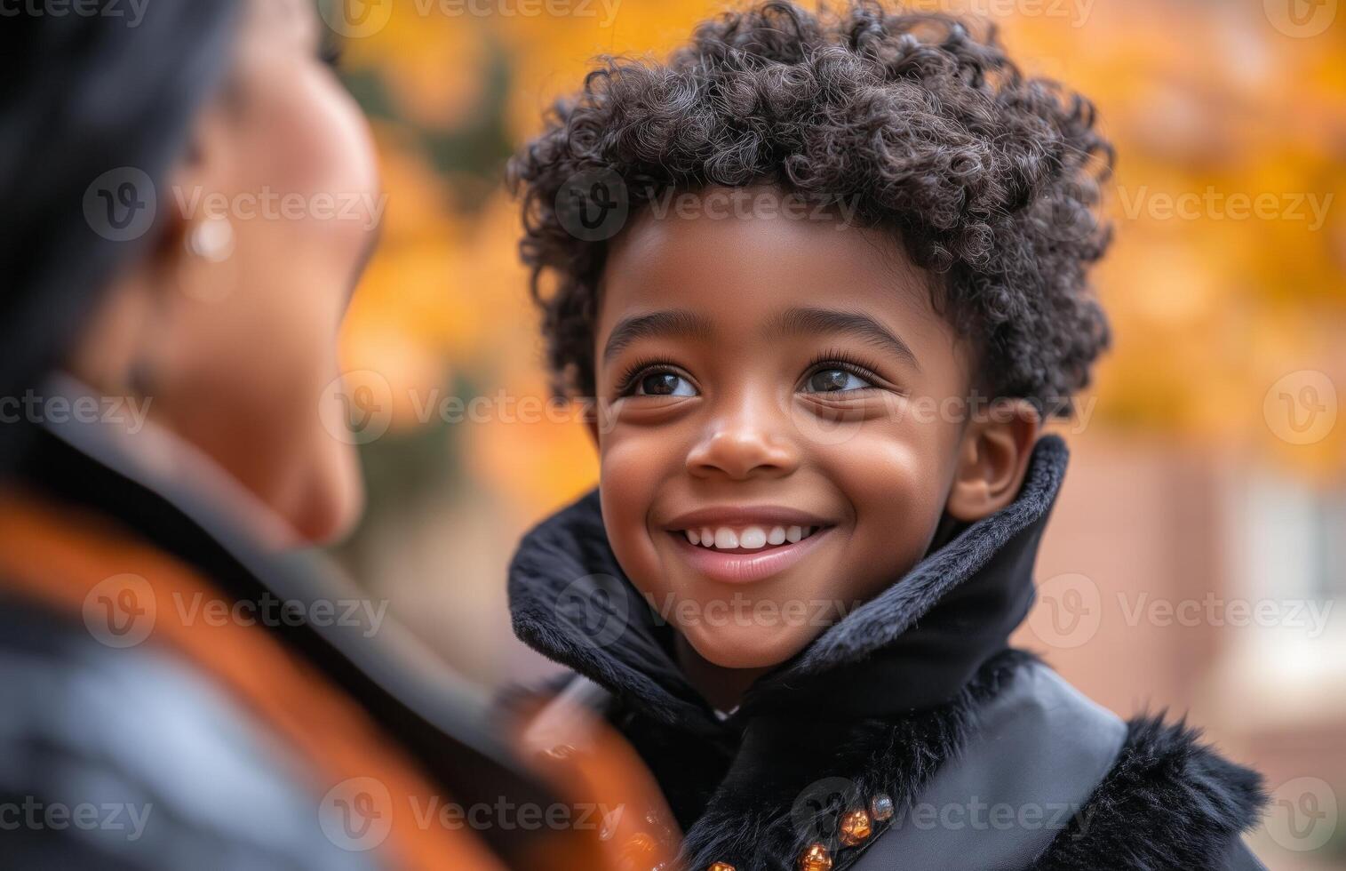 A young Black boy happily dressed as a vampire, smiling proudly at his mother photo