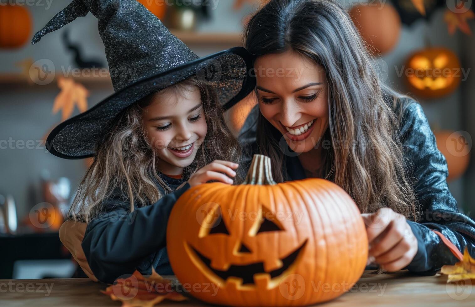 A mother and daughter sit at a table decorating a pumpkin for Halloween in festive costumes photo