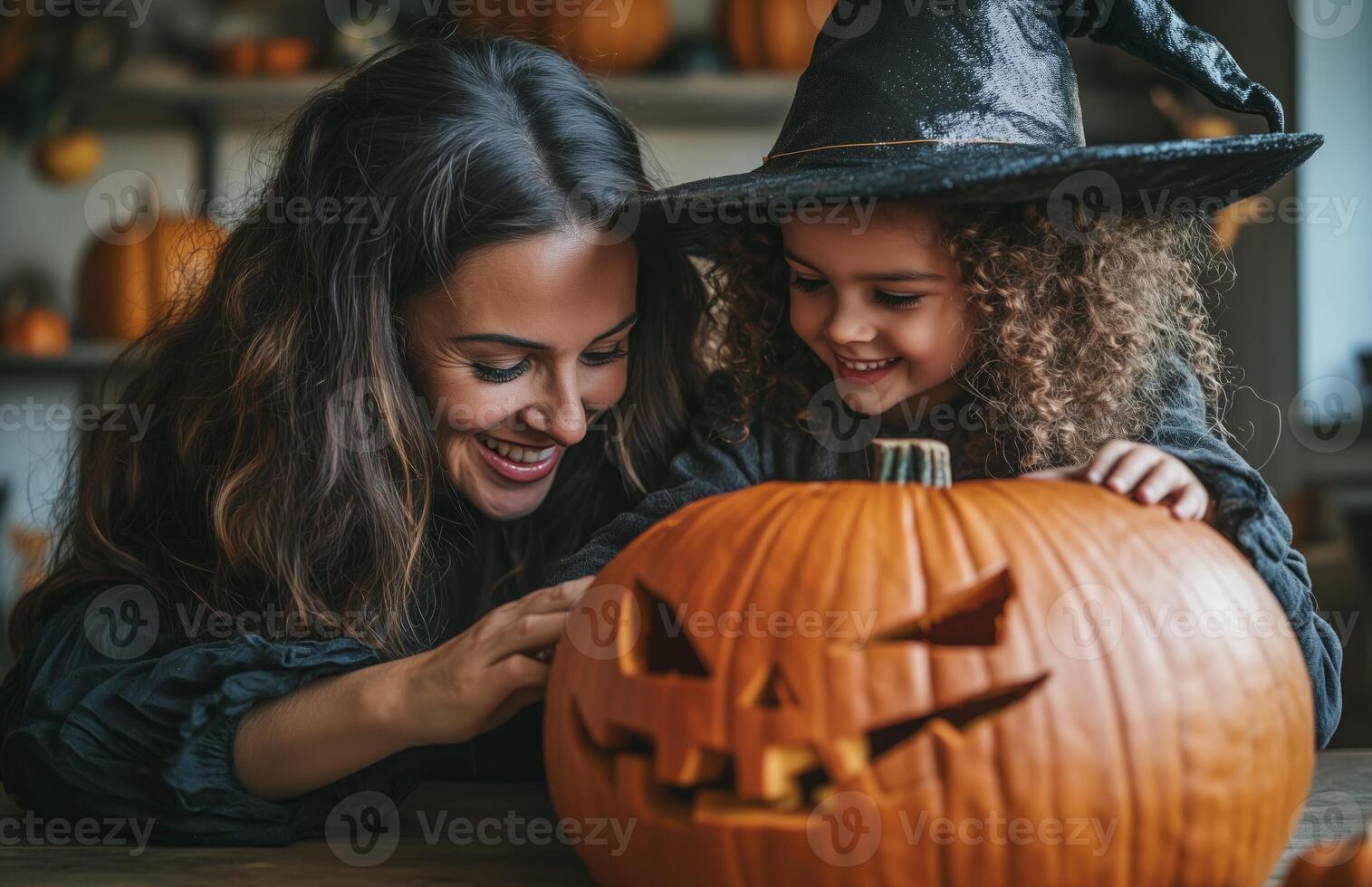 A mother and daughter sit at a table decorating a pumpkin for Halloween in festive costumes photo