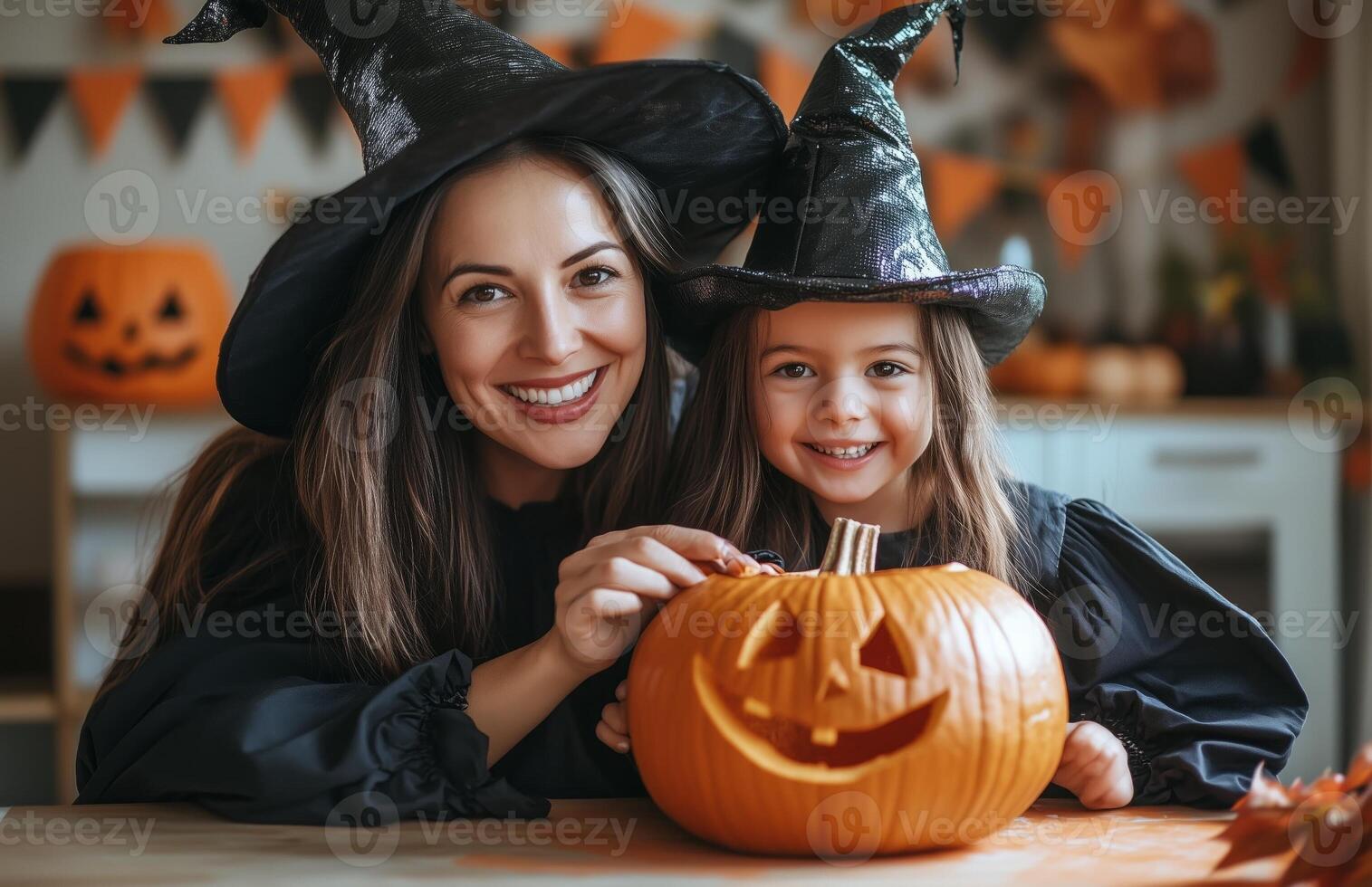 A mother and daughter sit at a table decorating a pumpkin for Halloween in festive costumes photo