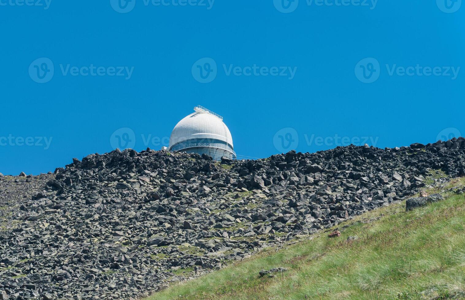 observatory on top of a mountain against a blue sky photo