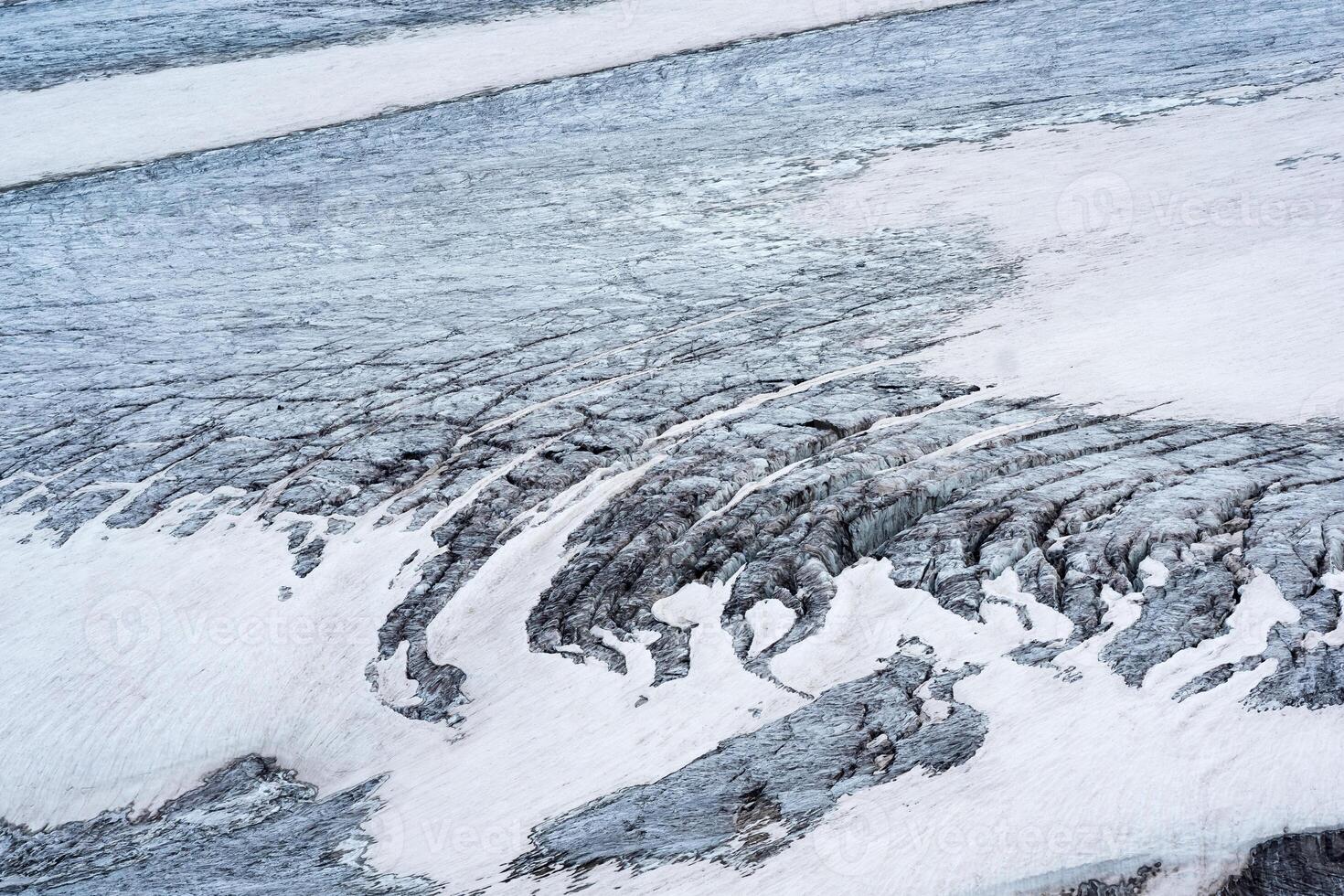 view of the surface of a high mountain glacier with crevasses photo