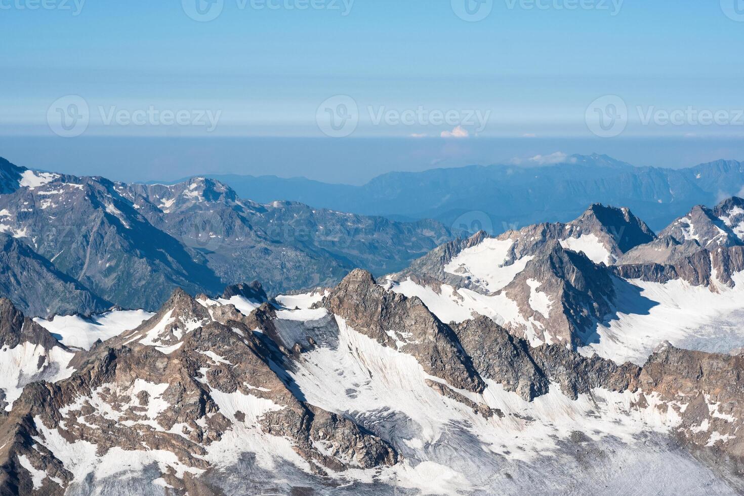 high mountainous landscape, mountain ranges with glaciers in atmospheric haze photo