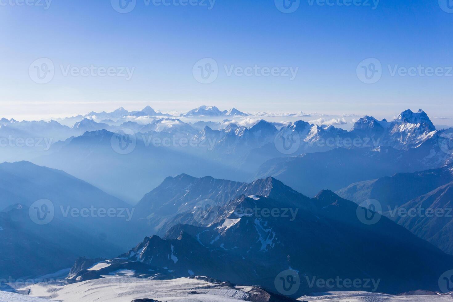view from highland glacier to misty mountains in the rays of dawn photo