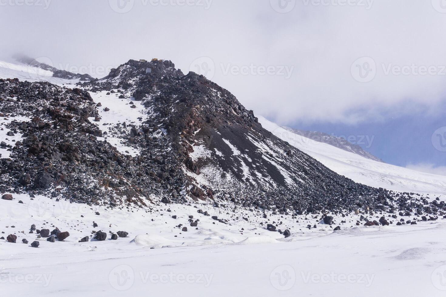 highland mountain landscape, snow-capped basalt rocks on the slope of Elbrus, 5000 meters above sea level photo