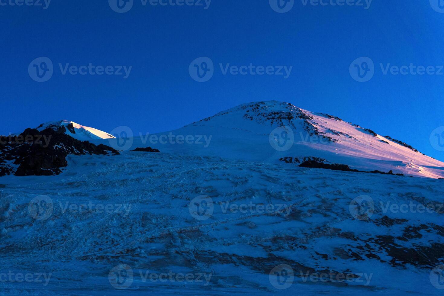 view of snowy peaks of mount Elbrus in the early dawn rays. Elbrus is the highest peak in Europe photo