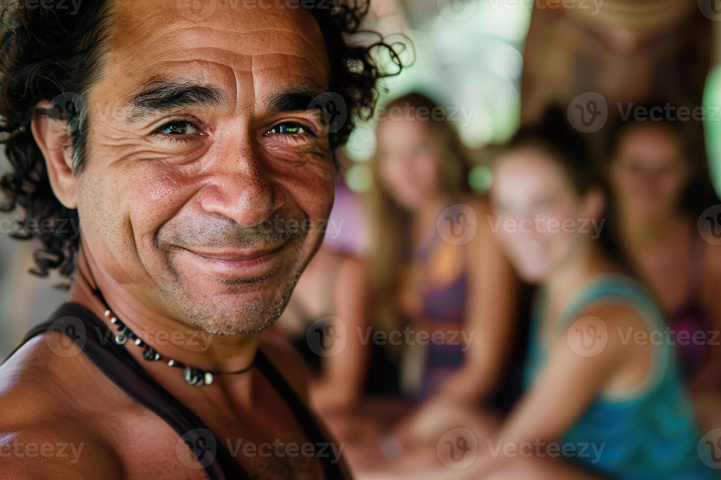 Happy Hispanic male yoga instructor smiling with group. photo
