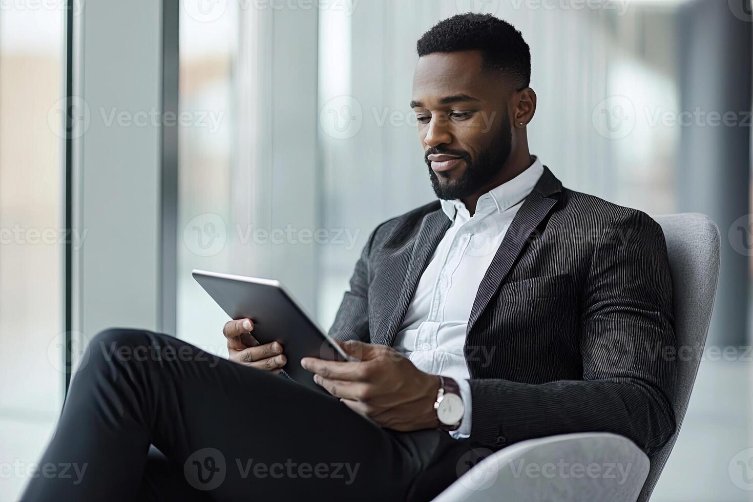 Close up of young businessman using digital tablet while sitting at his working place in office. Businessman using digital tablet photo