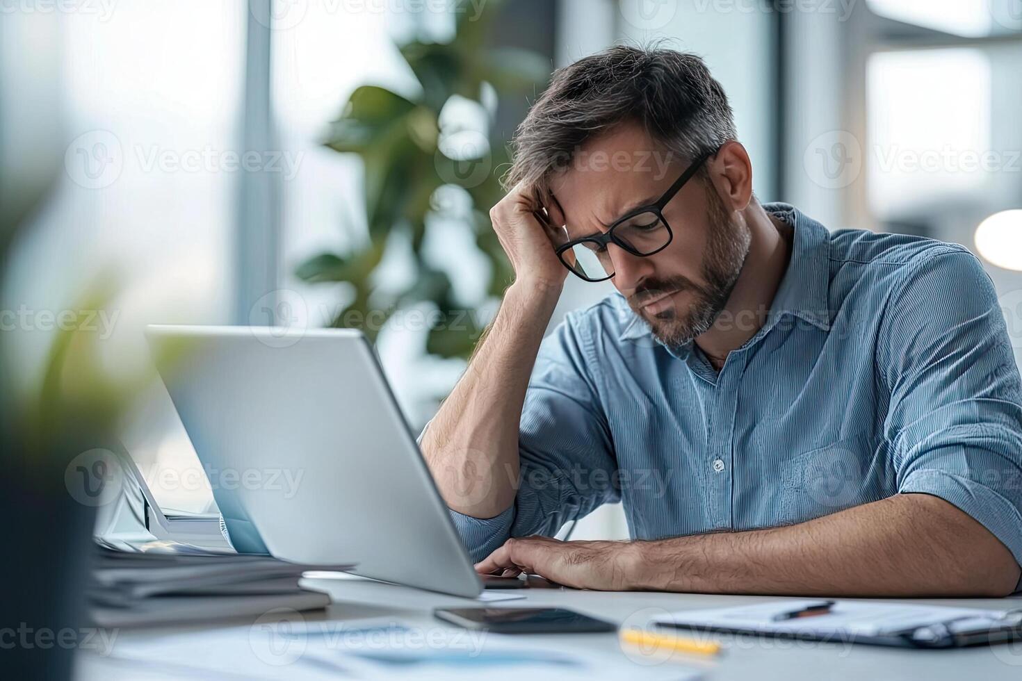 Close up of young businessman using digital tablet while sitting at his working place in office. Businessman using digital tablet photo