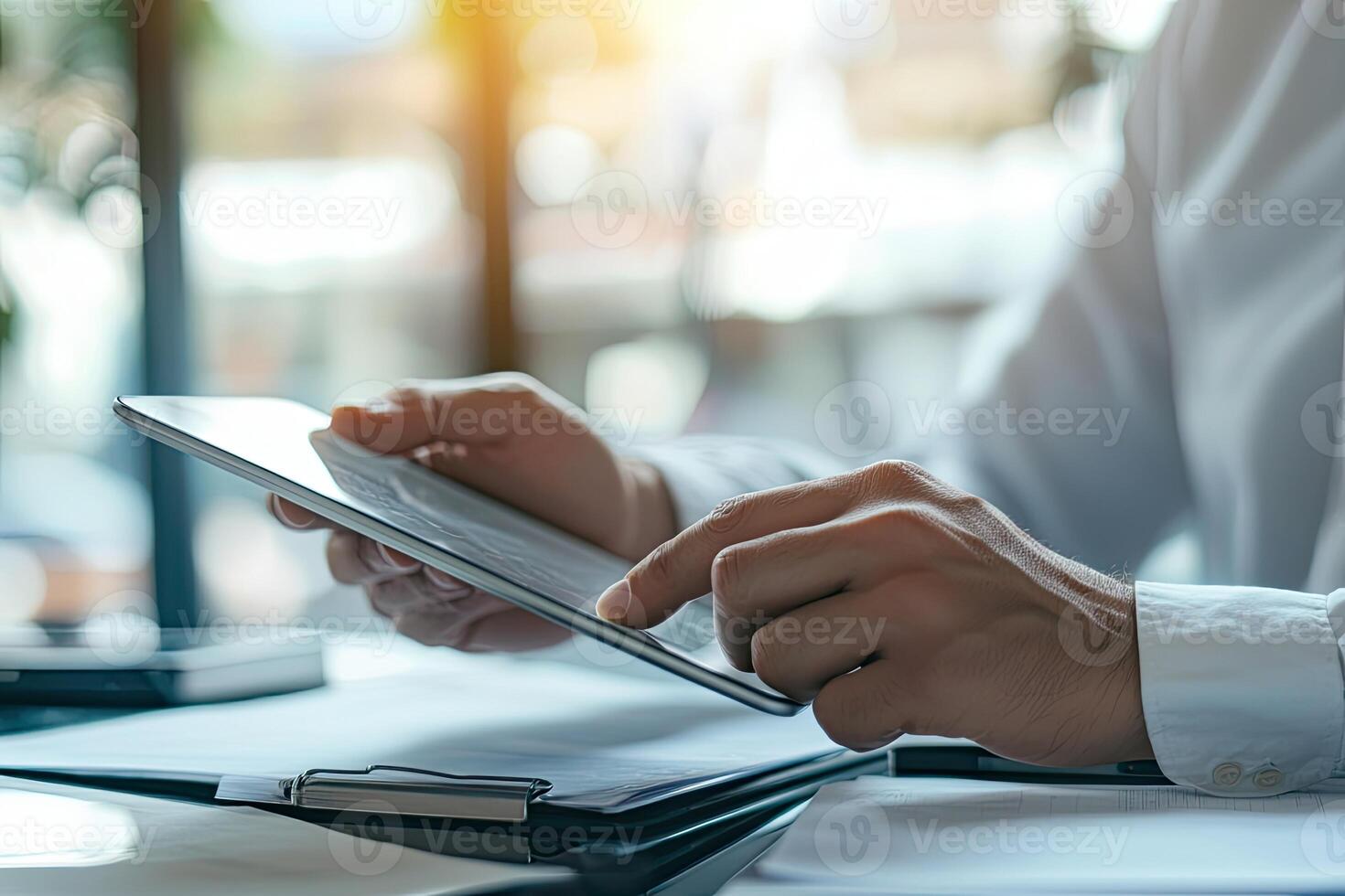 Close up of young businessman using digital tablet while sitting at his working place in office. Businessman using digital tablet photo