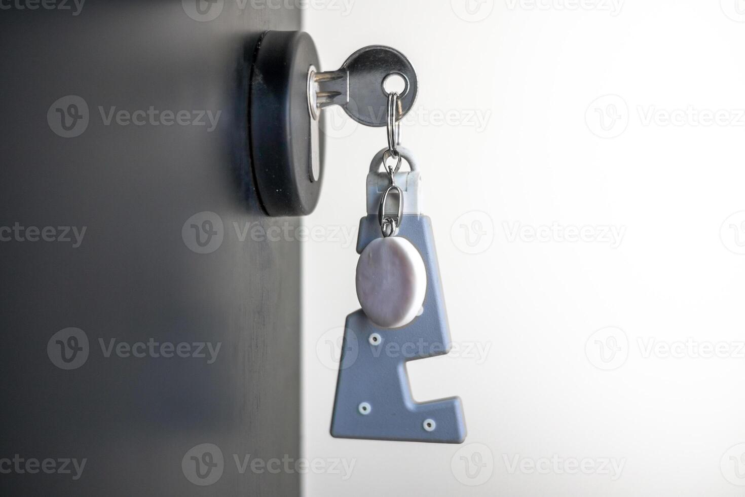 A house key with a key ring inserted at the door lock. Buy new home or concept photo