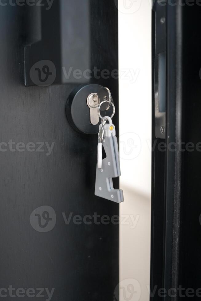 A house key with a key ring inserted at the door lock. Buy new home or concept photo