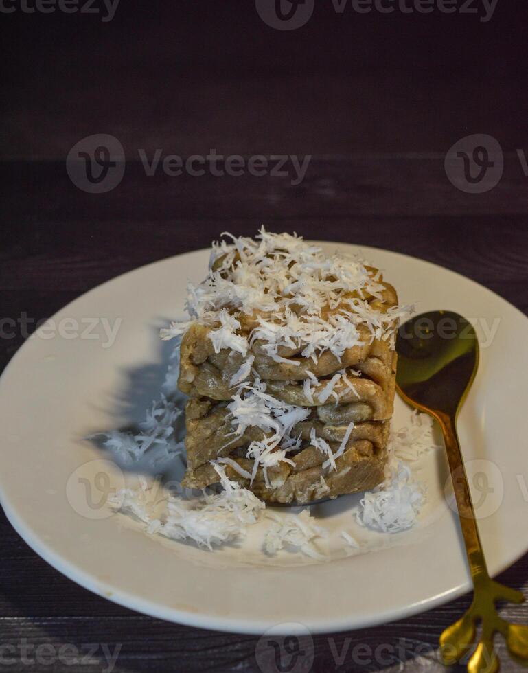Textured, made from processed cassava that is steamed and mashed. Served with grated coconut. photo