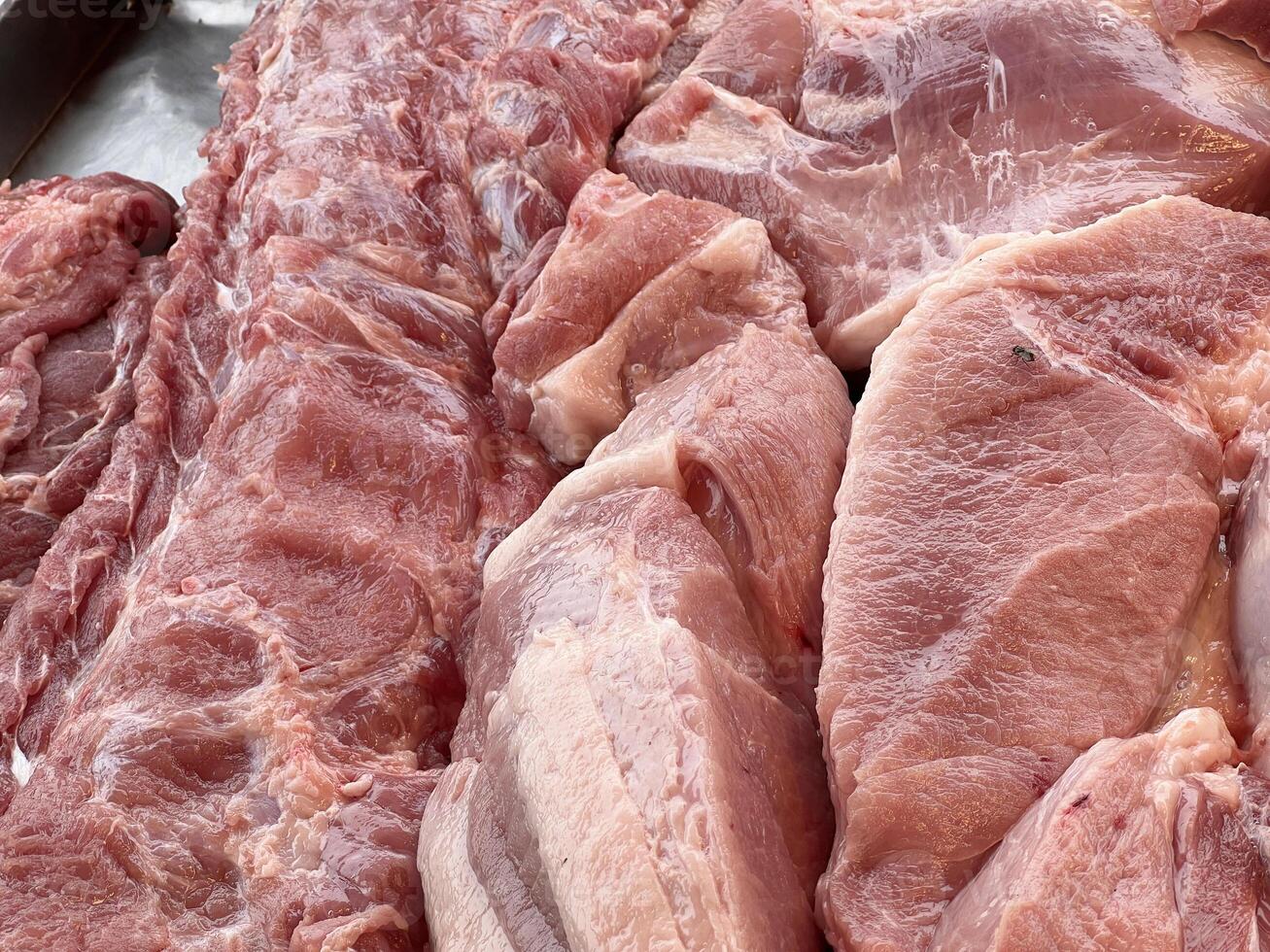 close up of raw pork meat on the market counter photo